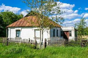 linda e velha casa de fazenda abandonada na zona rural em fundo natural foto