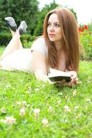 uma jovem atraente mulher com uma livro foto