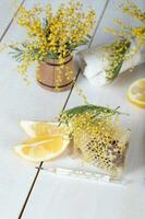 mimosa flores, favo de mel, dois peças do limão foto