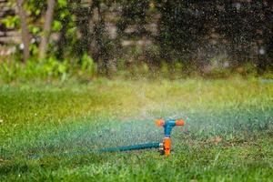 irrigador de jardim regando grama foto