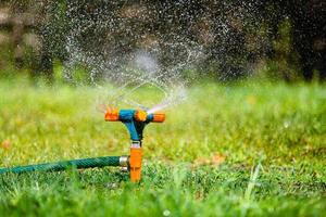 irrigador de jardim regando grama foto