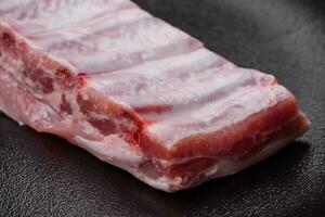 cru carne de porco costelas com carne com sal, especiarias e ervas foto