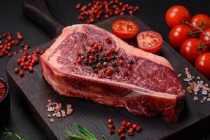 fresco suculento cru Novo Iorque carne bife com sal, especiarias e ervas foto