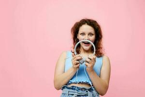 elegante menina com fones de ouvido música Diversão Rosa fundo inalterado foto