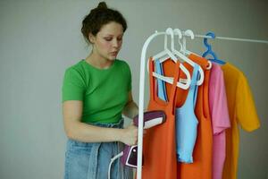 bonita mulher tentando em roupas guarda roupa juventude estilo isolado fundos inalterado foto