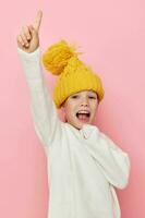 retrato do feliz sorridente criança menina dentro uma suéter e uma chapéu infância inalterado foto