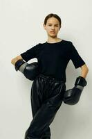 jovem mulher dentro boxe luvas dentro Preto calça e uma camiseta isolado fundo foto