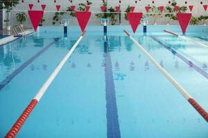 a esvaziar Esportes piscina com uma vermelho dividindo caminho. azul água dentro a natação piscina. foto