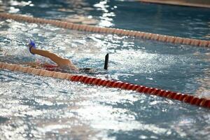 criança atleta nada dentro a piscina. natação seção. foto