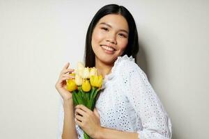 encantador jovem ásia mulher dentro uma branco camisa flores Primavera posando estilo de vida inalterado foto