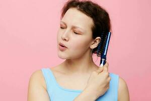 adolescente menina remove cabelo em uma pente insatisfação isolado fundo inalterado foto