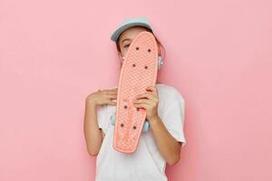 retrato do feliz sorridente criança menina com uma skate dentro mão infância inalterado foto