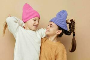 dois engraçado pequeno meninas dentro colorida chapéus posando foto