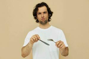 alegre homem emoções faca e garfo utensílios de cozinha bege fundo foto