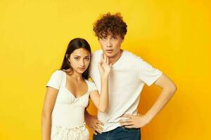 jovem Garoto e menina posando juntos dentro branco Camisetas amizade amarelo fundo inalterado foto