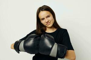 jovem mulher dentro Preto Esportes uniforme boxe luvas posando estilo de vida inalterado foto