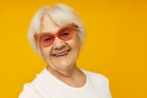 sorridente idosos mulher visão problemas com óculos amarelo fundo foto