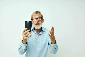 velho homem gestos com dele mãos uma vidro do beber isolado fundo foto