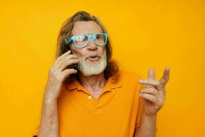 velho homem vestindo azul óculos amarelo camisa falando em a telefone cortada Visão foto