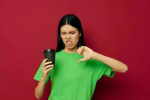 mulher dentro uma verde camiseta Preto vidro com uma beber desprazer foto