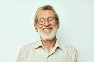 retrato do feliz Senior homem com uma cinzento barba dentro uma camisa e óculos isolado fundo foto