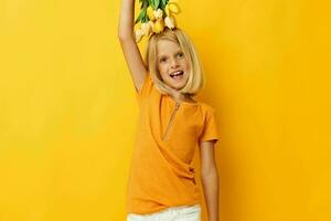 fofa pequeno menina com loiro cabelo uma ramalhete do amarelo flores foto