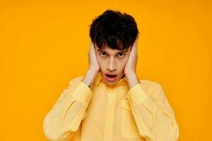 alegre homem dentro amarelo camisa posando moda gesto com mãos foto