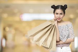 mulher compradora atraente segurando sacolas de compras foto