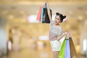 mulher compradora atraente segurando sacolas de compras