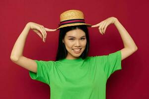 retrato ásia lindo jovem mulher sorrir verde camiseta chapéu posando moda vermelho fundo inalterado foto