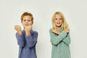 Garoto e menina dentro multicolorido blusas posando para Diversão luz fundo foto