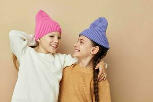 dois fofa pequeno meninas vestindo chapéus moda infância foto