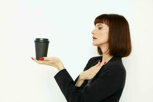 lindo mulher dentro uma Preto terno uma caneca com uma beber charme isolado fundo foto