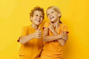 retrato do fofa crianças abraço moda infância entretenimento amarelo fundo inalterado foto