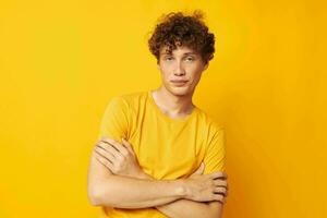 retrato do uma jovem encaracolado homem amarelo camiseta óculos moda mão gestos monocromático tiro foto