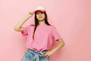 jovem menina dentro uma Rosa camiseta com uma boné em dela cabeça casual vestem foto