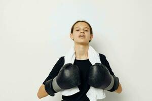 jovem mulher com toalha boxe Preto luvas posando Esportes estilo de vida inalterado foto