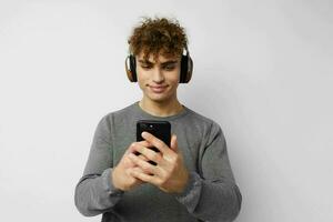 bonito jovem homem olhando às a telefone fones de ouvido moda estilo de vida inalterado foto