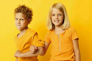 fofa pré escola crianças dentro amarelo Camisetas em pé lado de lado infância emoções amarelo fundo foto