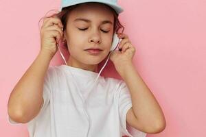 retrato do feliz sorridente criança menina vestindo fones de ouvido posando emoções infância inalterado foto
