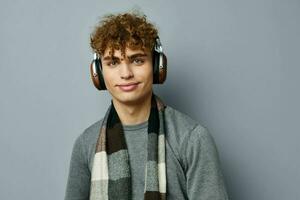 bonito jovem homem moda posando fones de ouvido isolado fundo foto