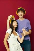 uma jovem casal dentro colorida Camisetas à moda roupas chapéus juventude estilo foto