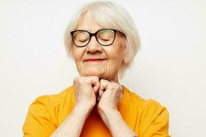 retrato do a velho amigáveis mulher dentro casual camiseta e óculos isolado fundo foto