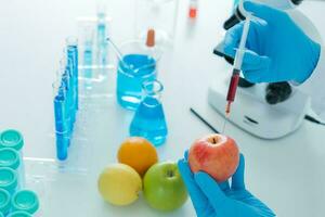 cientista Verifica químico Comida resíduos dentro laboratório. ao controle experts inspecionar qualidade do fruta, cientistas injetar produtos químicos para dentro maçãs para experimentos, perigos, Proibido substância, contaminar foto