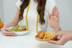 beleza fino fêmea corpo confundir gordo Comida. mulher dentro restaurante atinge peso perda objetivo para saudável vida, baixo caloria, fino cintura, nutricionista. dieta, corpo forma, Saldo ao controle, evitar, nutricional foto