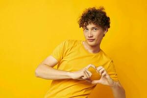 cara com vermelho encaracolado cabelo vestindo à moda amarelo camiseta posando isolado fundo inalterado foto