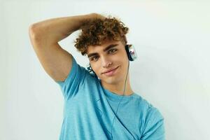 bonito jovem homem dentro azul Camisetas fones de ouvido moda estilo de vida inalterado foto