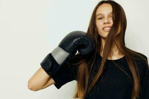 jovem lindo mulher dentro Preto Esportes uniforme boxe luvas posando isolado fundo foto