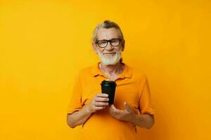 retrato idosos homem com Preto descartável copo amarelo fundo foto