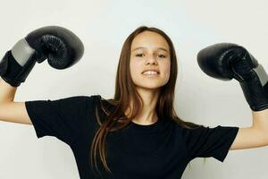 jovem mulher dentro Preto Esportes uniforme boxe luvas posando estilo de vida inalterado foto